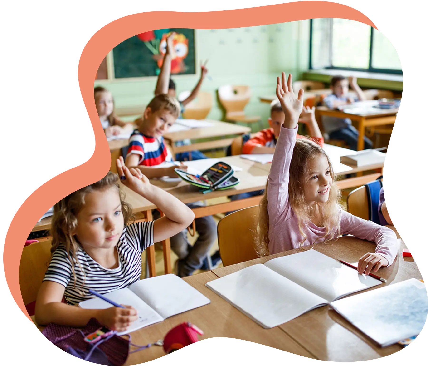 Mehrere Kinder in einer Schulklasse heben die Hände.